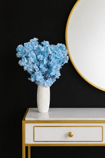 Elegant artificial flowers in a textured white plastic vase