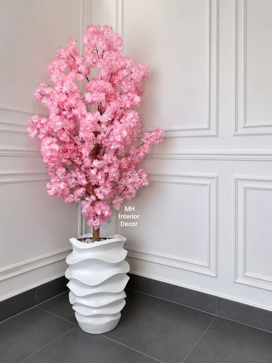 Artificial pink cherry blossom tree in a sculptural white planter